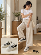 Female model wearing Weekend Edit Frayed Canvas Trainers, with shoe close-up and Moussewear logo